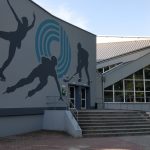 Contemporary ice rink entrance featuring a dynamic skating mural outside.