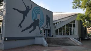 Contemporary ice rink entrance featuring a dynamic skating mural outside.